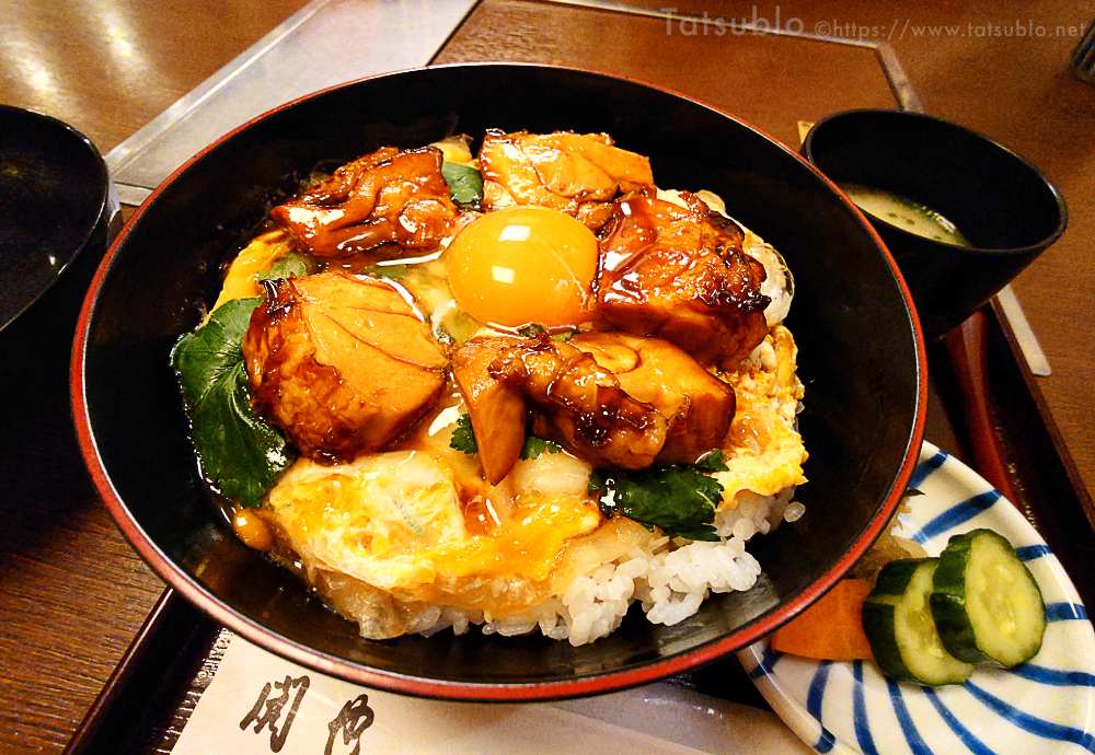 テカテカの照り焼きの鶏の上に生卵、ご飯の上にはとじた玉子が乗っています。